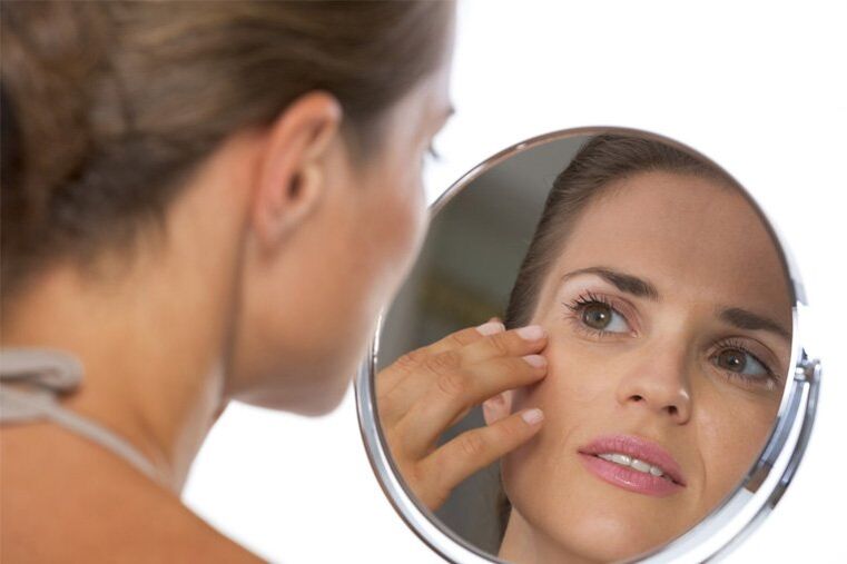 girl looking in mirror before skin rejuvenation